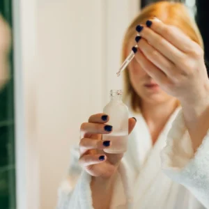 Woman using a dropper to apply serum