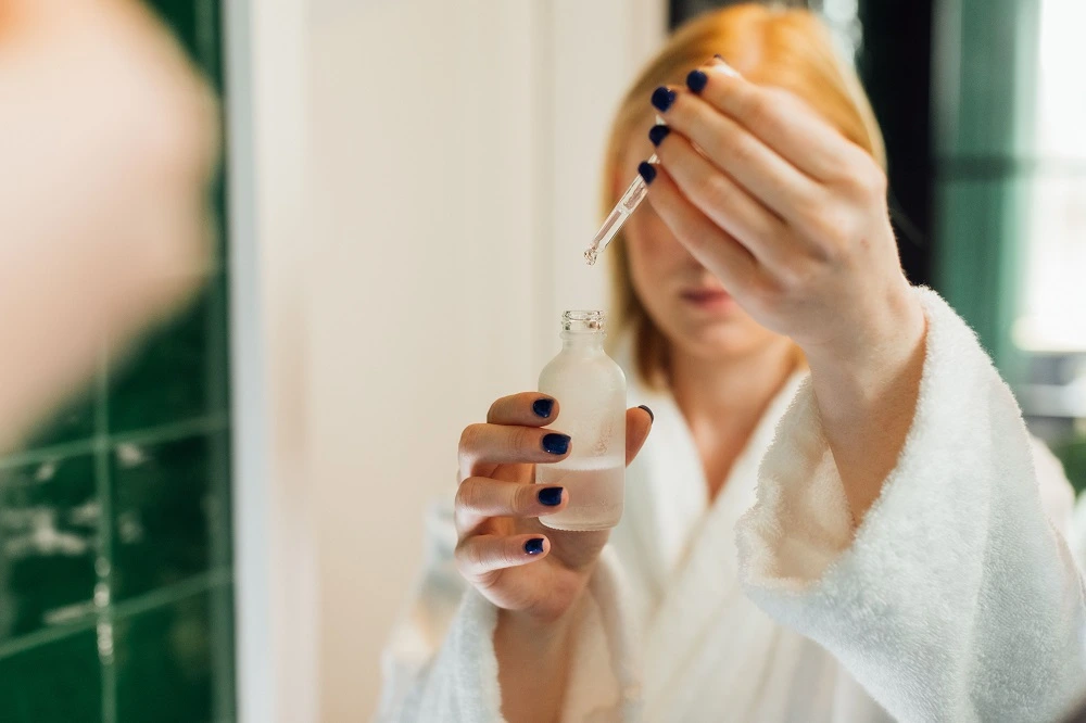 Woman using a dropper to apply serum