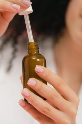 woman using a dropper bottle, focusing on skincare and beauty routine